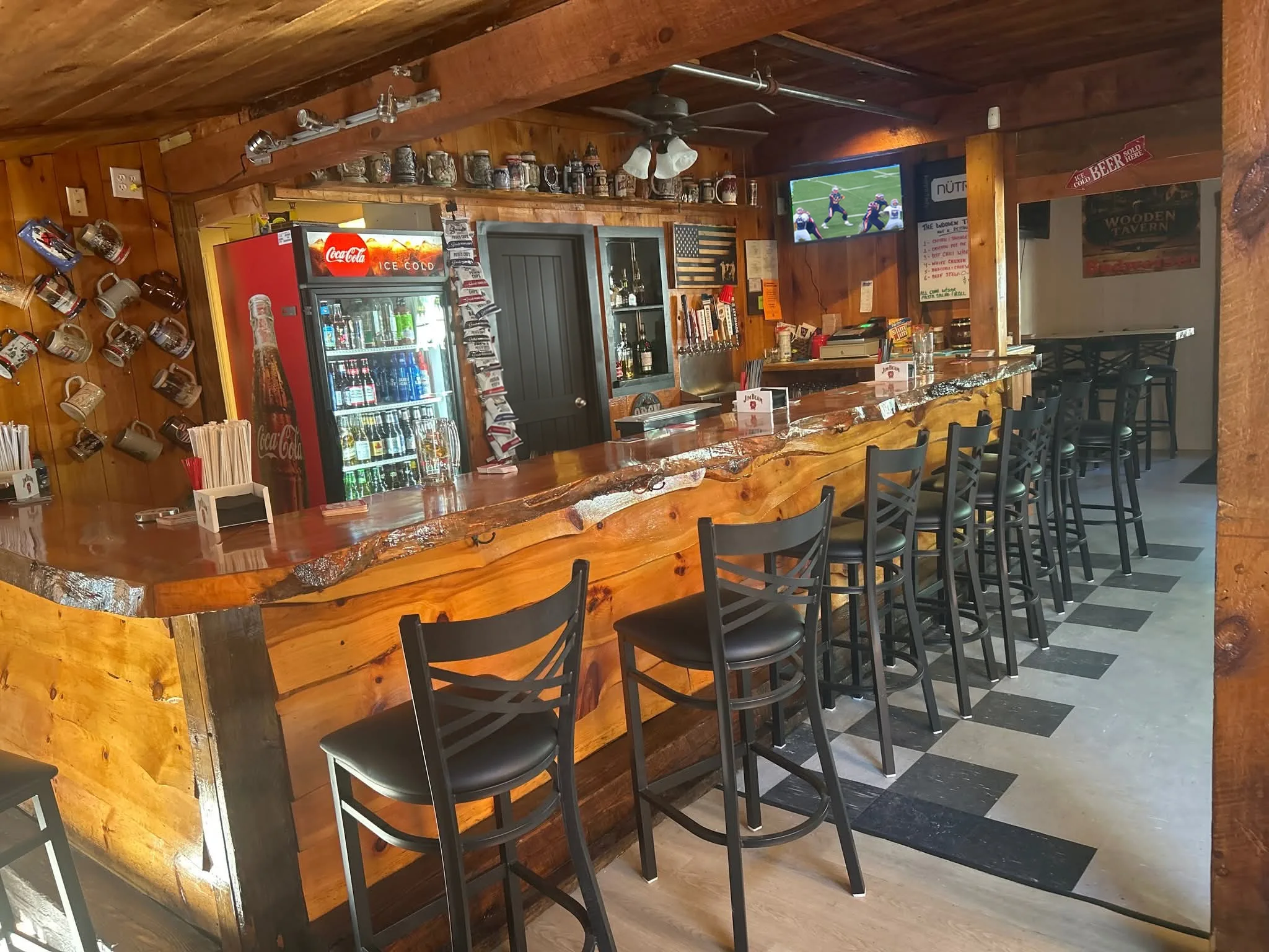 The Wooden Tavern's wooden bar, stools, and television